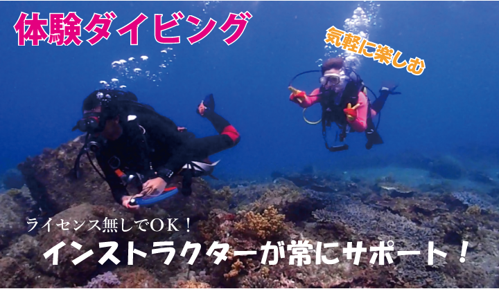 先導するインストラクターと、サンゴの上を泳ぐ若い女性がこちらにピース。体験ダイビングでの海中の様子を収めた写真。